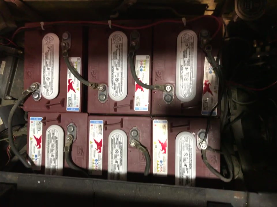 Six new Trojan deep-cycle batteries wired in the EZGO's battery compartment