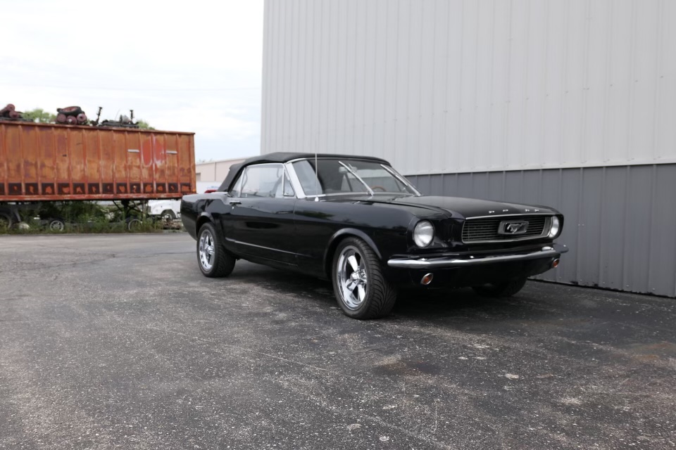 The completed black 1966 Mustang convertible parked outside
