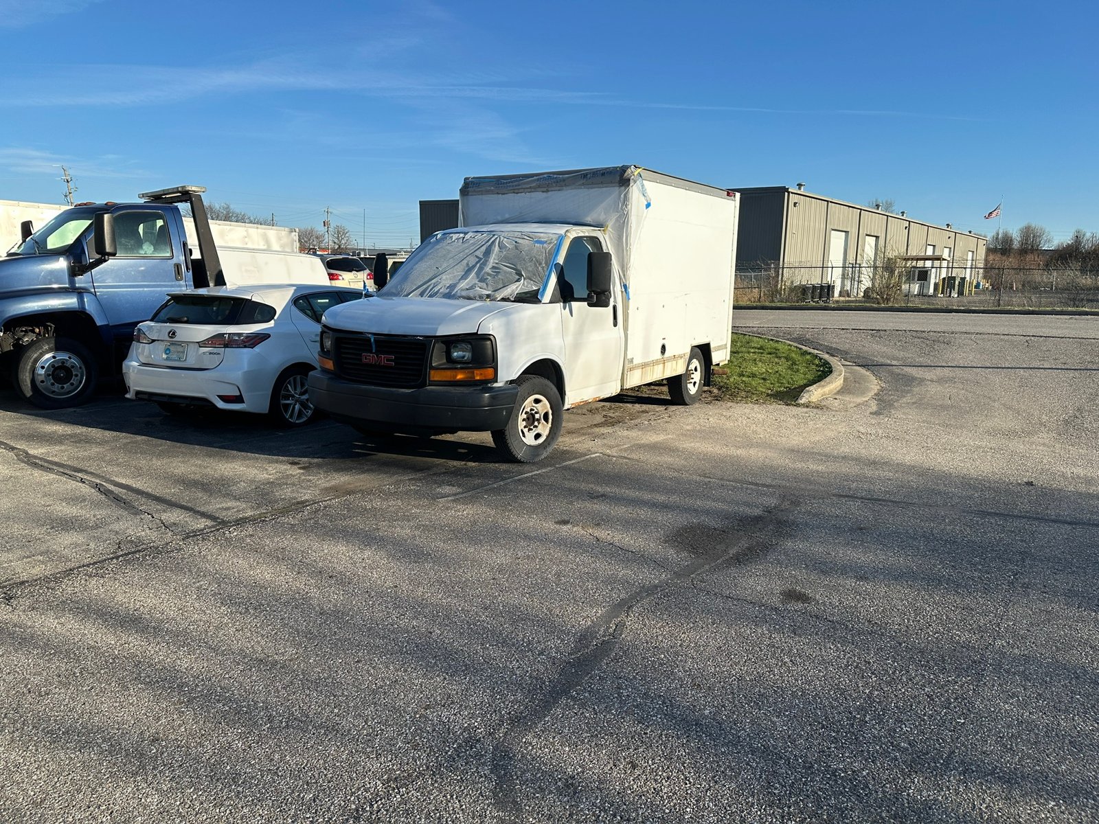 The van masked off in plastic after painting the hood, fenders, and cab roof at the shop